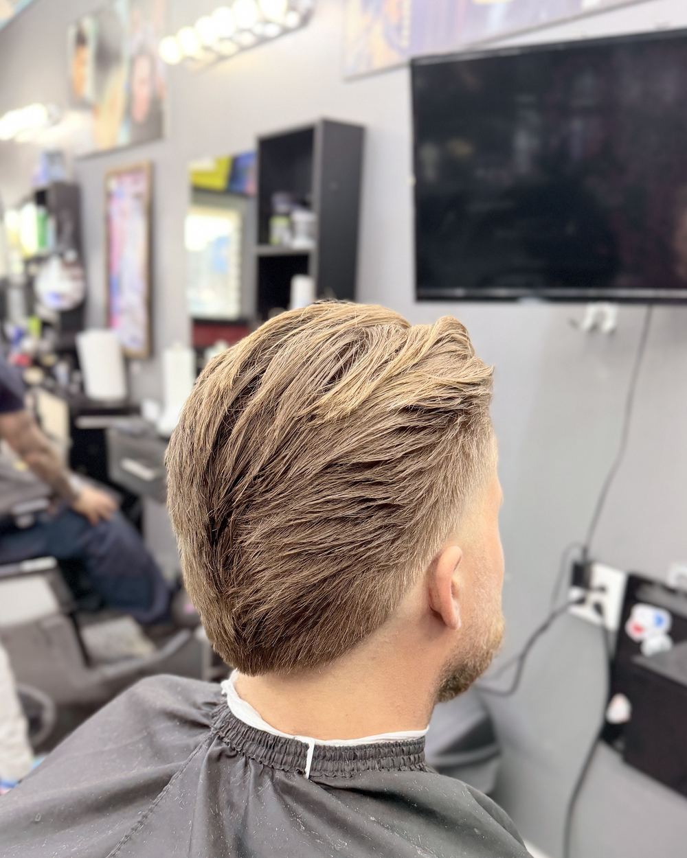 Slicked-back blond hair with a clean taper, seen from behind