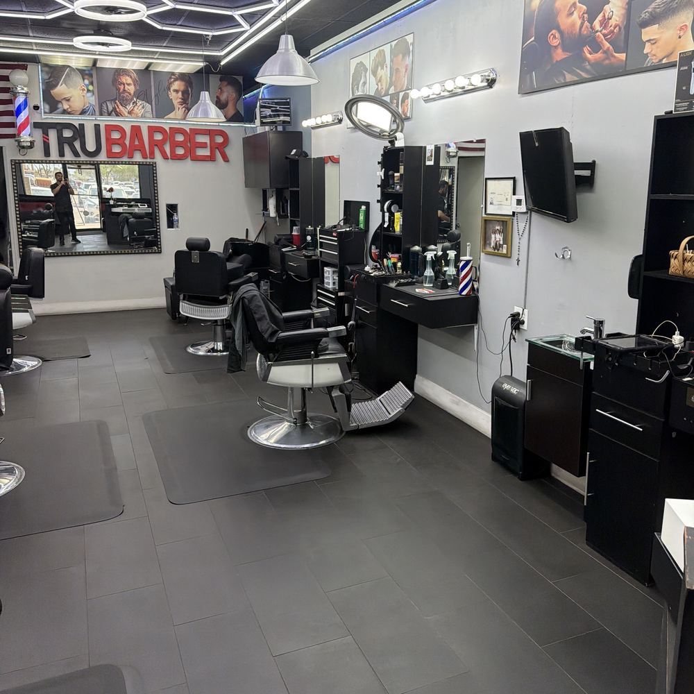 The Tru Barber sign, the flag and the barber pole above the chairs